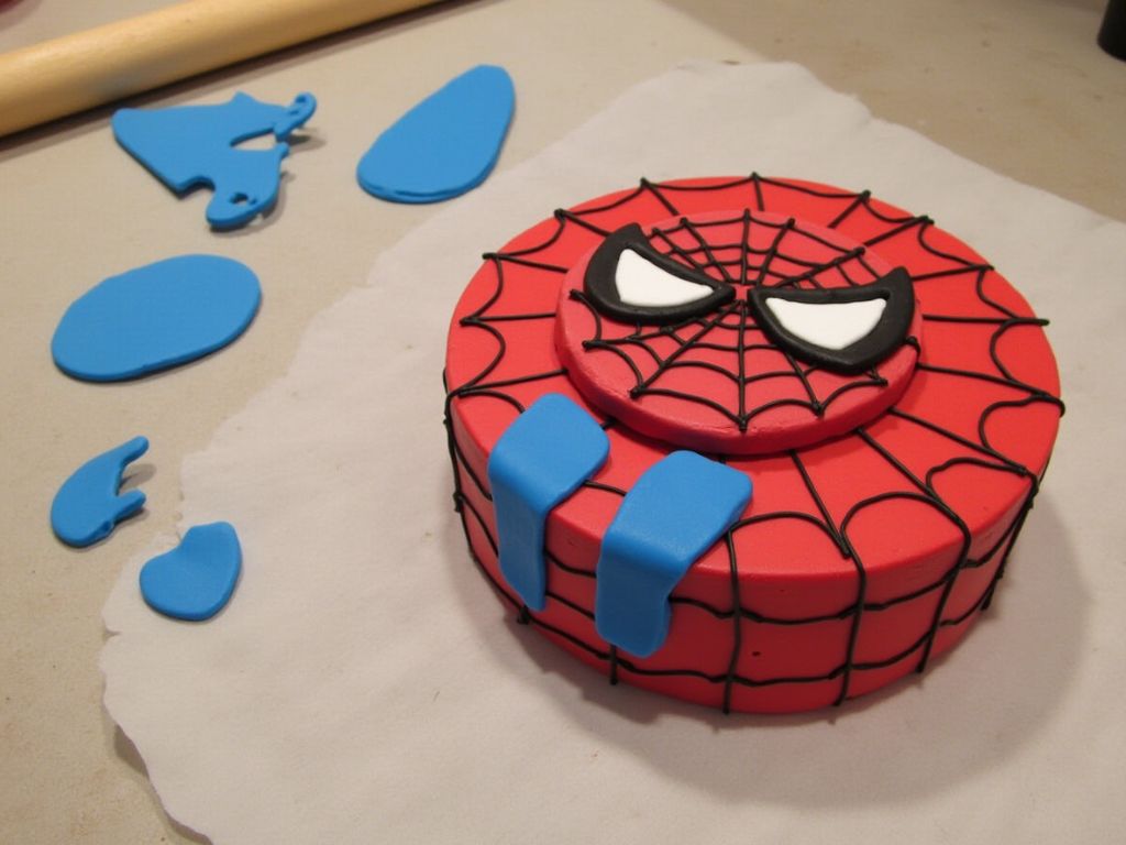 Step-by-step preparation of Spider Man cake design with red fondant and blue accents